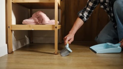 Woman Sweeping Floor In Hallway