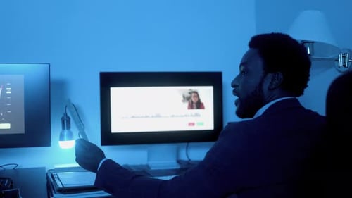 Business African trader investor making stock market analysis video call inside office at night