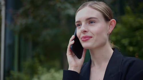 Happy Blonde Woman Talking on Phone Outdoors