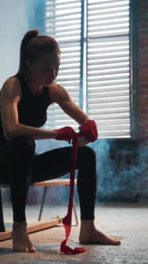 Woman Wrapping Hands for Boxing Preparation Indoors