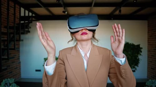 Woman gesturing while using a Virtual Reality headset in an office