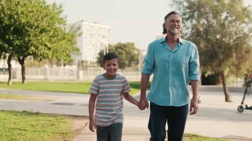 Grandfather And Grandson Walking In The Park