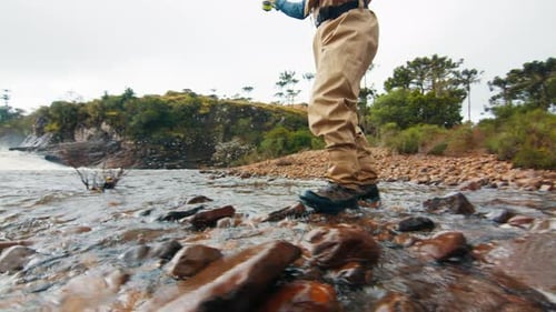 Fly Fisherman Wading in a Rocky River