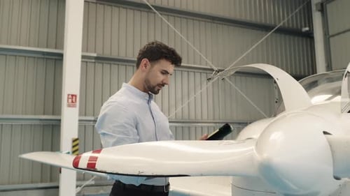 Aircraft Engineer Inspecting Propeller with Tablet in Slow Motion