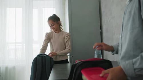 Girl and Boy Wearing Casual Clothes Preparing for School By Placing Lunch Containers