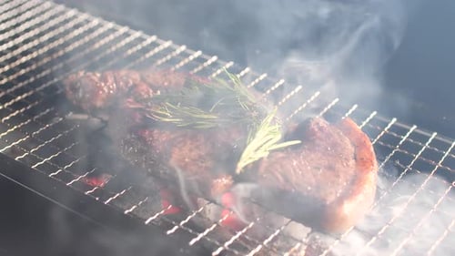 Sirloin steak is grilled on flame and smoke. Grilled steak with charcoal stove.