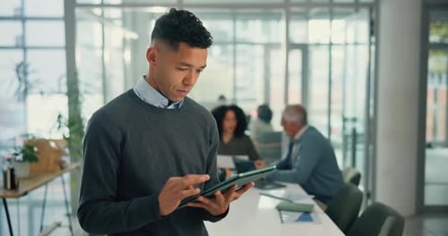 Young Man Uses Tablet in Modern Office