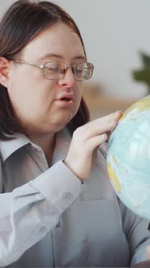 Young Adult Exploring Globe Indoors