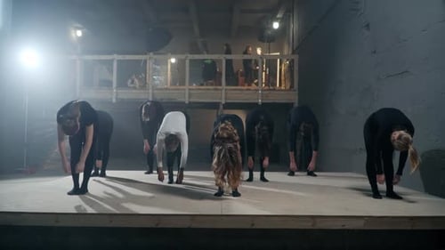 People Onstage Stretching and Rehearsing a Performance