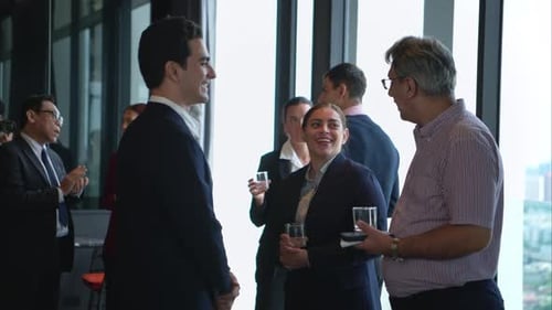 Business professionals networking and enjoying drinks at a corporate event in a modern office