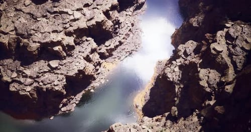 Vibrant Canyon River Reflecting Sunlight in Serene Natural Landscape