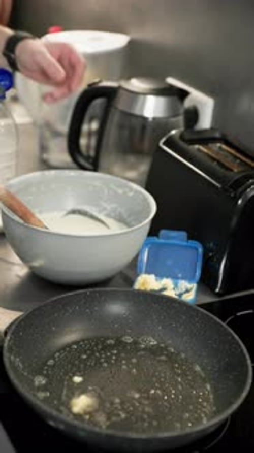 Person cooking a pancake in the kitchen