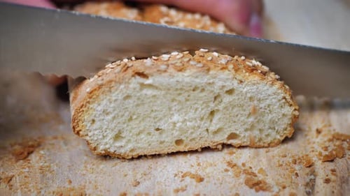 Close Up of Knife Slicing Crusty Bread