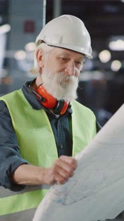 An Older Man in a Hard Hat Inspects a Construction Project
