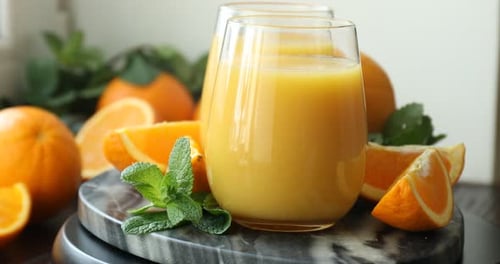 Fresh Orange Juice in Glasses with Sliced Oranges