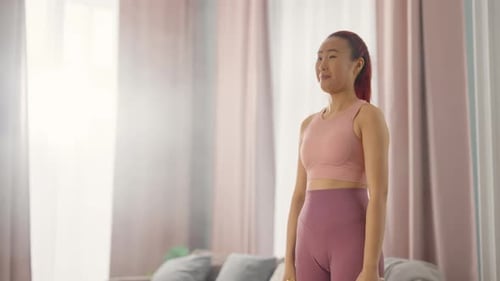 Athletic Woman Doing Bicep Curls in Bright Living Room
