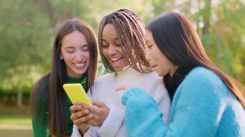 Happy Young Women Sharing a Mobile Phone