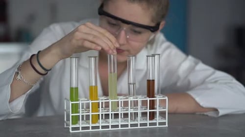 Scientist Analyzing Liquid in Test Tubes in Lab