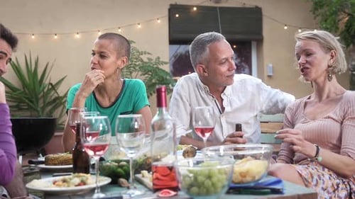 Friends Sharing Meal Together at an Outdoor Table