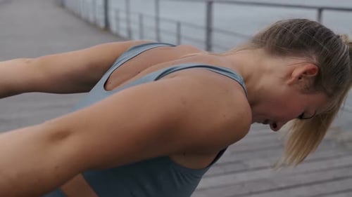 Woman Stretches Arms on Paved Path Outdoors