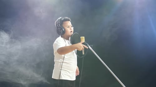 Young Boy Singing Into Microphone in Smoky Room