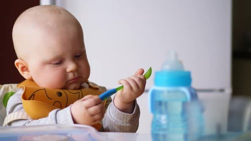 Adorable Infant Eating Food from a Spoon