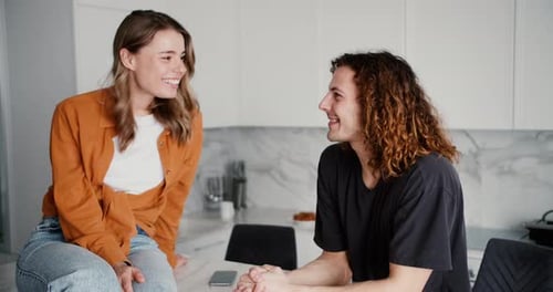 Woman and Man Smiling and Laughing in Kitchen