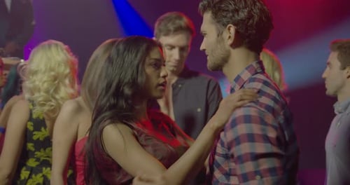 Couple dancing at a party with other people