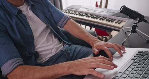 A musician is creating new music in his home studio.