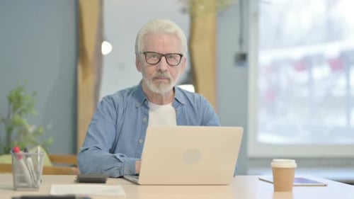Man with Gray Hair Working on Laptop