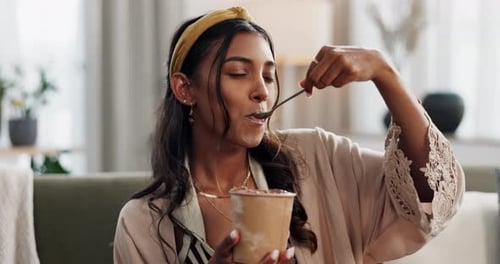 Woman on sofa eating ice cream with smile, taste and relax with sweets in living room