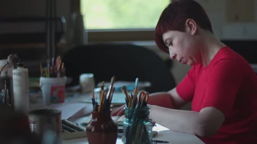Artist Sketching in Notebook Studio Space on Artwork Surrounded by Artist'S Tools,