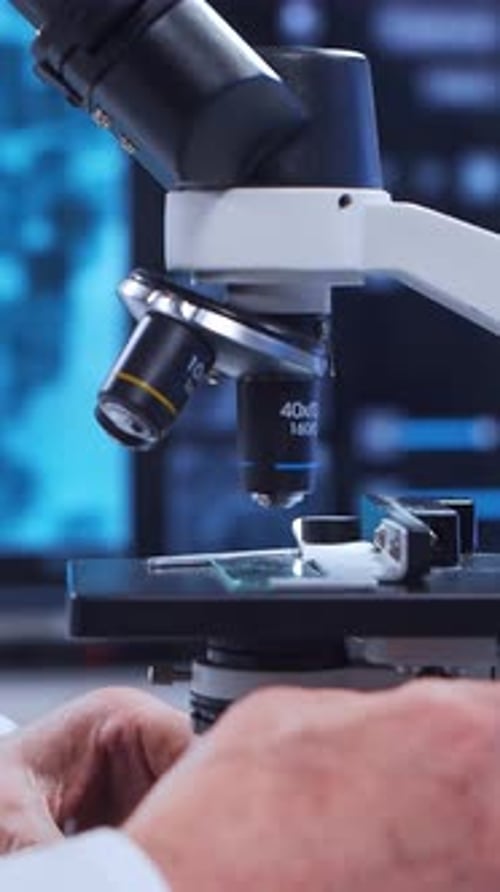 Senior Scientist Looking Through Microscope in Laboratory