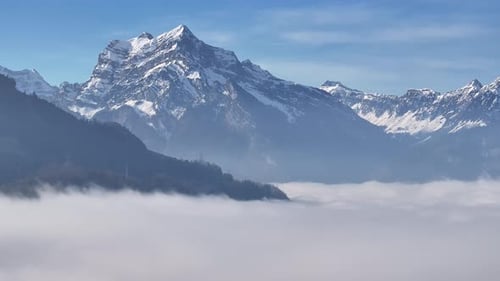 Alpine peaks piercing through a sea of clouds, Swiss Alps