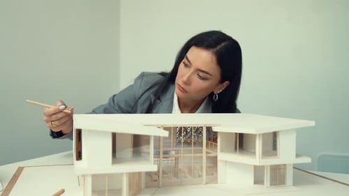 Professional young architect engineer measure house model length. Immaculate.