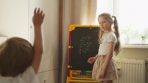 Young Girl Teaches Boy Math at Home