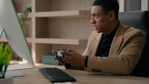 Young Man Plays Video Games at His Office Desk