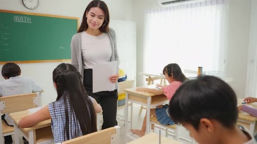 Group of student learn with teacher in classroom at elementary school.