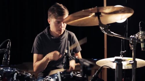Music, People, Musical Instruments and Entertainment Concept - Male Musician with Drumsticks