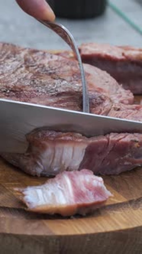 Cutting Juicy Steak on Wooden Board