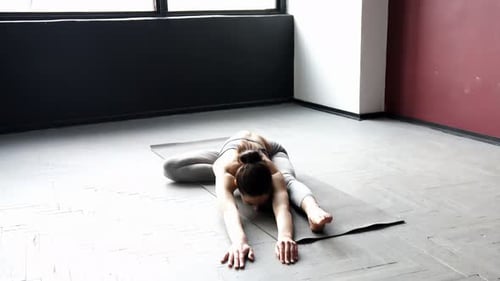 Athletic Woman Stretching on Yoga Mat Indoors