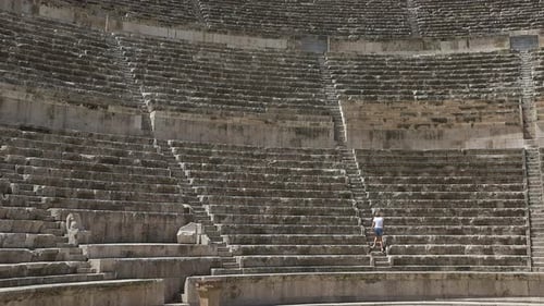 Older people travel. People exploring the world. Senior man and woman in the ancient greek theatre.