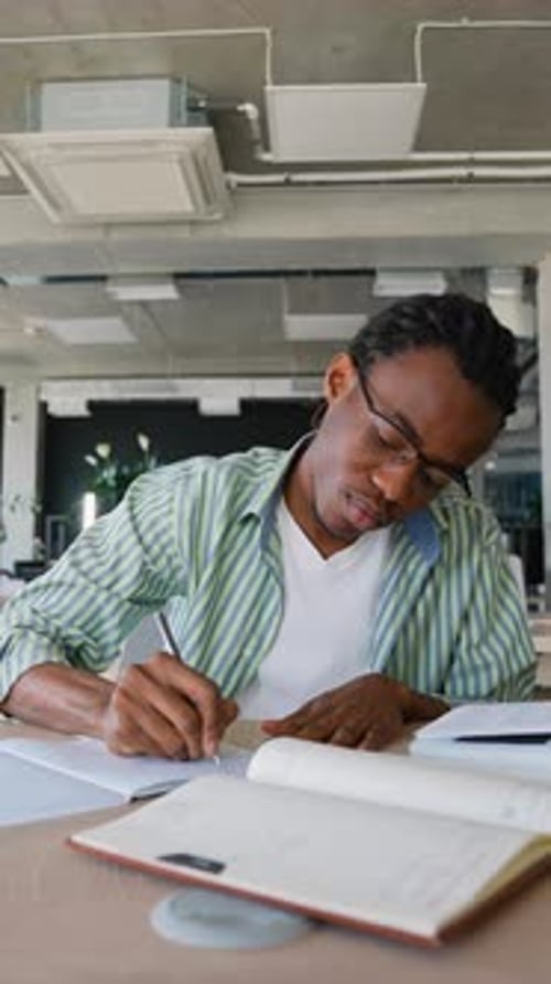 African American Student Writing Notes in Library