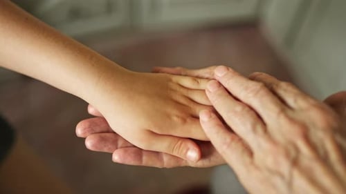 Child and Senior Hands Touching in Comforting Gesture