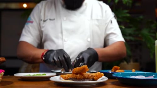 Restaurant Chef Plating Fish with Sauce and Cabbage