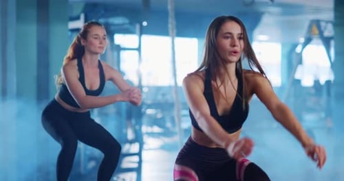 Women Exercising and Doing Squats in Gym