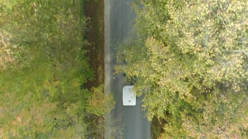 Overhead View Of A Car With Trailer Driving In The Tree-lined Road. - aerial