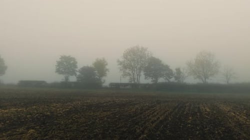 Foggy Rural Landscape with Plowed Autumn Field and Trees Fading Into Dense Mist Mist Swirling with