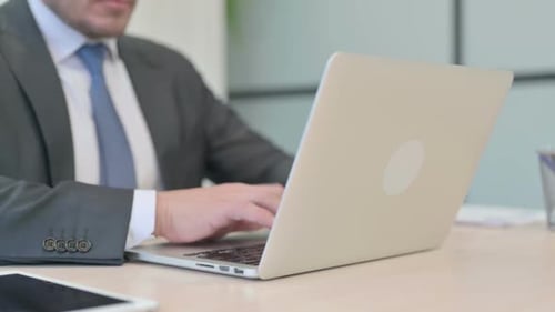 Close Up of Businessman Typing on Laptop Keyboard