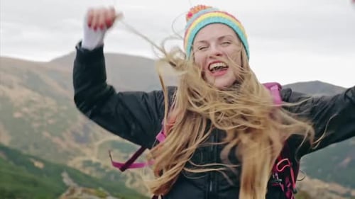 Young Girl Stretching Her Arms on Top of a Mountain Feeling Success